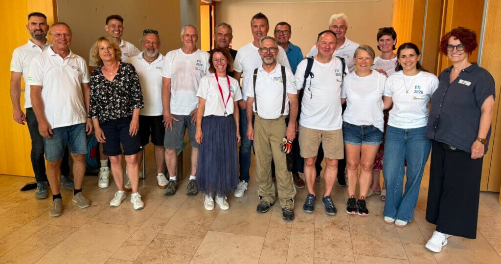 Gruppe von ehrenamtlichen Helfern der Energietage 2026 in einem Innenraum, einige tragen weiße T-Shirts mit Aufdruck, andere legere Kleidung
